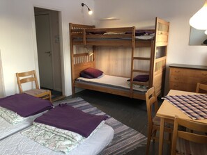 A dormitory room with two bunk beds, a desk, a chair, and a small cabinet. - Storliens Fjällgård  - Hostel (Storlien)