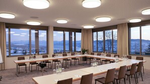 A conference room with a long table, chairs, and large windows offering a view of a snowy landscape.