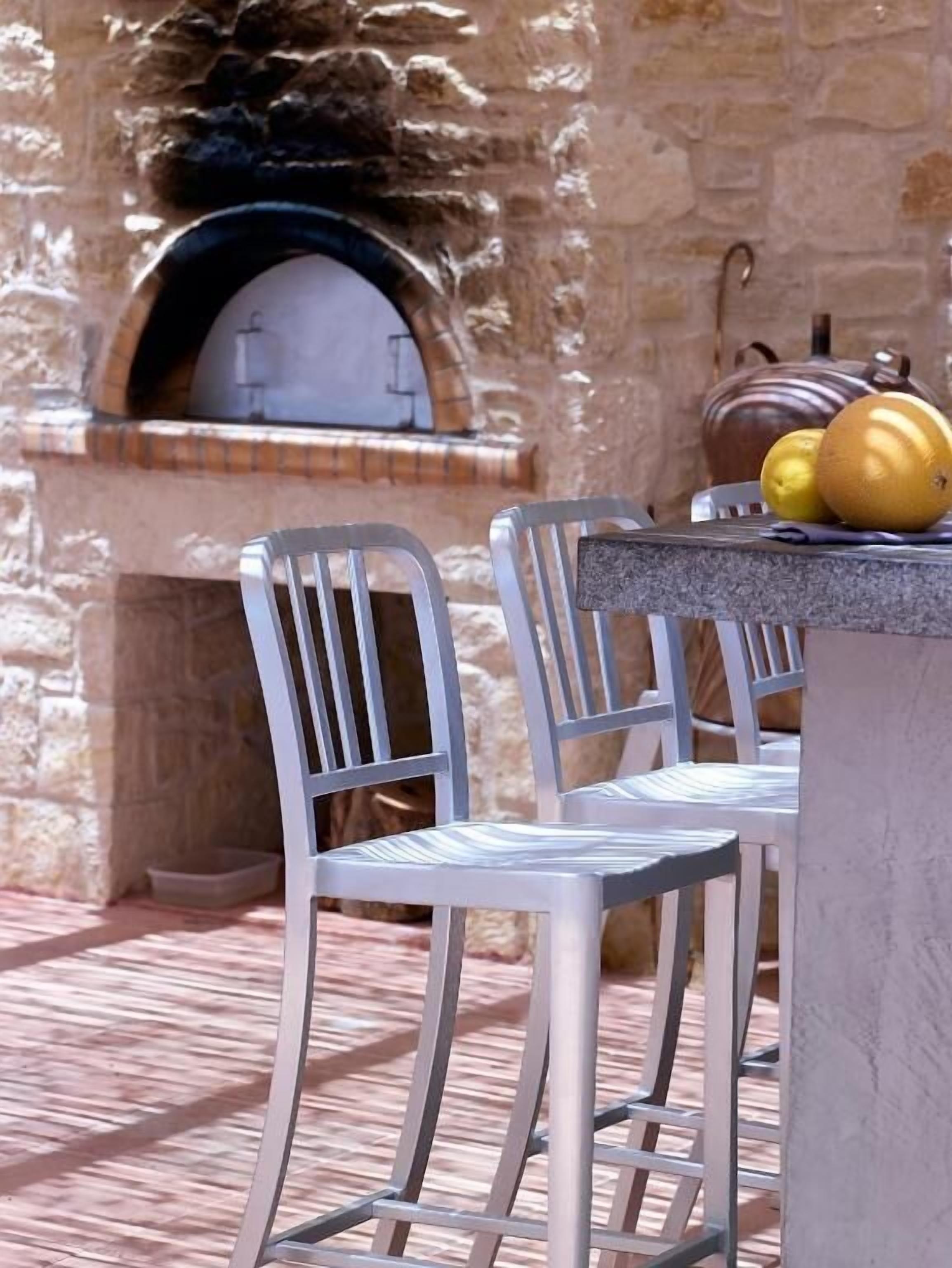 Un espace extérieur aménagé avec des murs en pierre et un four à pizza.
