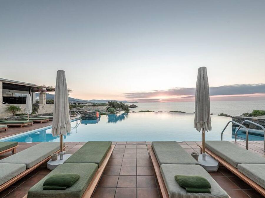 Una piscina al aire libre, sillones reclinables de piscina