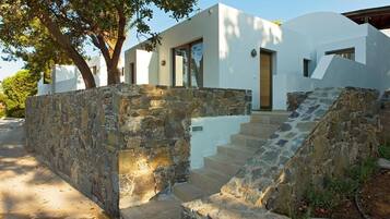 Una casa moderna con un muro de piedra y una escalera que lleva a la entrada.