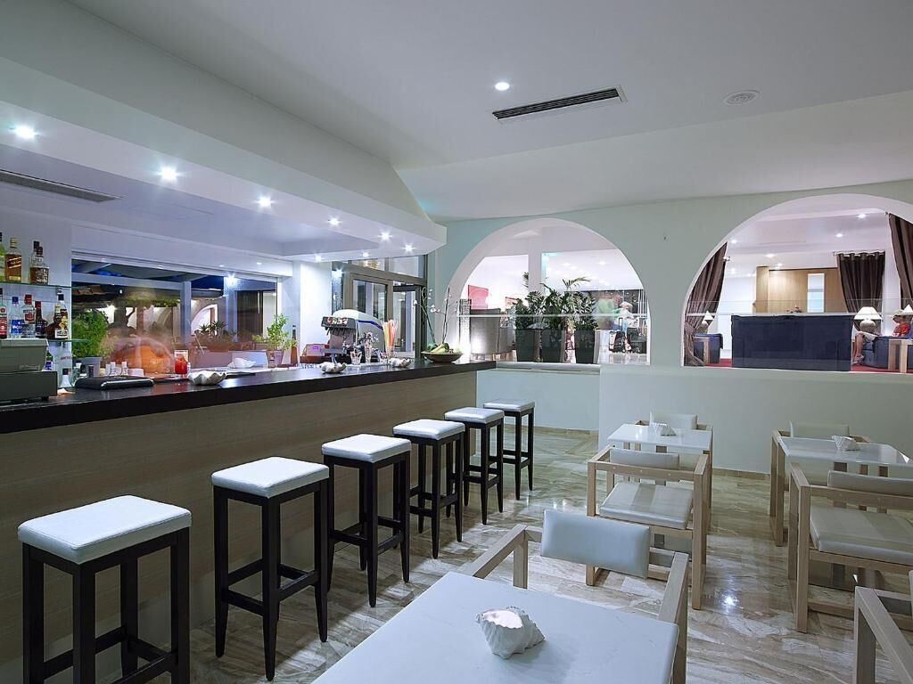 A modern restaurant with a bar area, high stools, and tables.
