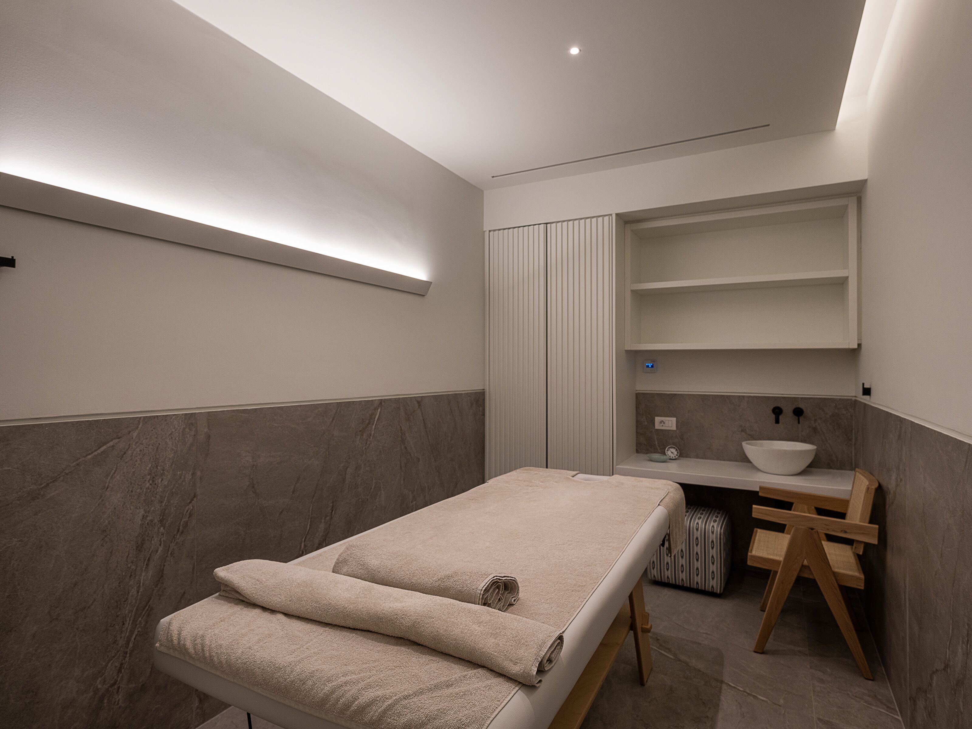 A modern bathroom with a built-in bench, a vanity with a bowl sink, and a towel rack.