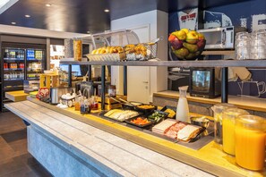 A buffet with various food items and beverages.