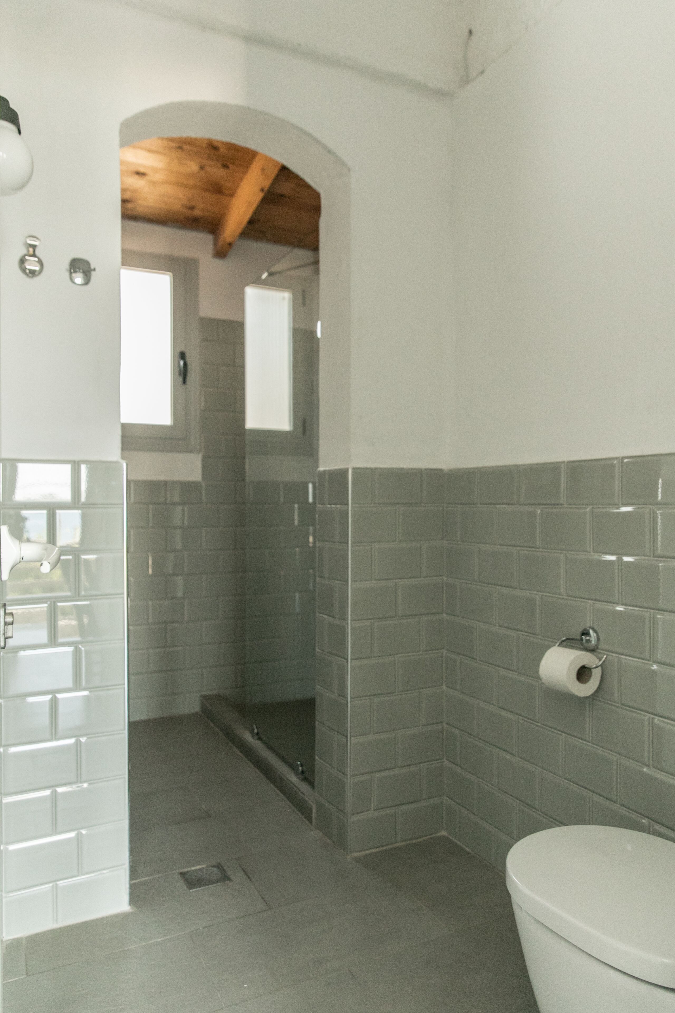 A bathroom with a shower, toilet, and a sink.