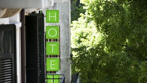 Un letrero de hotel con la palabra 'HOTEL' en letras verdes sobre la fachada de un edificio.