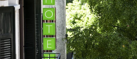 A hotel sign with the word "HOTEL" in green letters on a building facade.