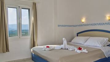A hotel room with a bed, a window with curtains, a view of the landscape, and a decorative wall pattern.
