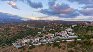 A coastal resort with villas, a swimming pool, and a winding road.