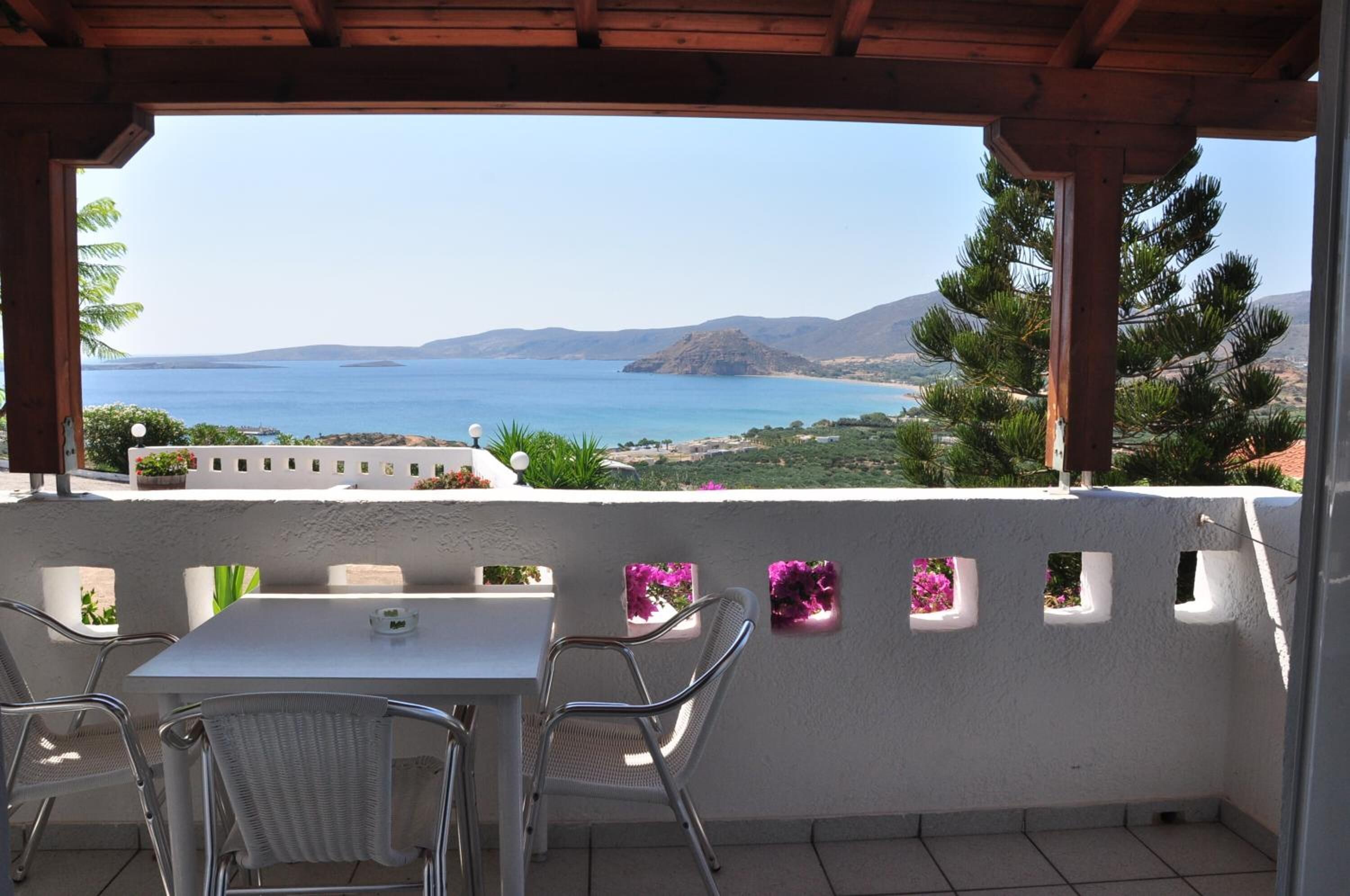 Un área de estar al aire libre, techada, con vistas al mar y a las montañas.