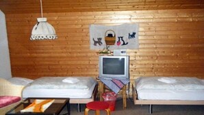 A small, cozy room with two beds, a television, a table, and a chair. - Hotel & Restaurant Alpenrose (Innertkirchen)