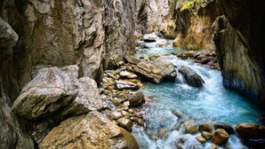 A narrow canyon with a flowing river, rocky terrain, and a metal railing on a cliff. - Hotel & Restaurant Alpenrose (Innertkirchen)