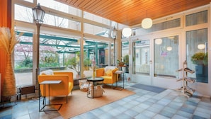 A modern interior with a wooden ceiling, large windows, and yellow furniture. - Hôtel du Grand-Pré (Marly)