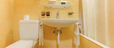 A bathroom with a toilet, sink, and shower curtain.