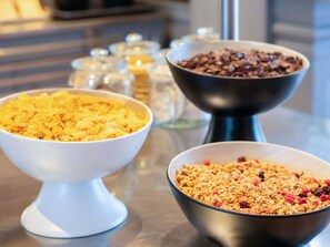 Three bowls of cereal on a table. - ibis budget Geneve Aeroport (Vernier)