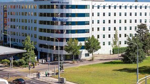 A modern hotel with a prominent 'Novotel Suites' sign, a 'His Budget' restaurant, and a view of mountains in the background. - ibis budget Geneve Aeroport (Vernier)