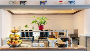 A modern kitchen with a fruit bowl, coffee station, and various food containers. - ibis budget Geneve Aeroport (Vernier)