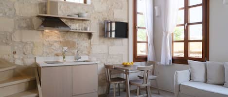 A compact living space with a kitchenette, a dining area, and a seating area.