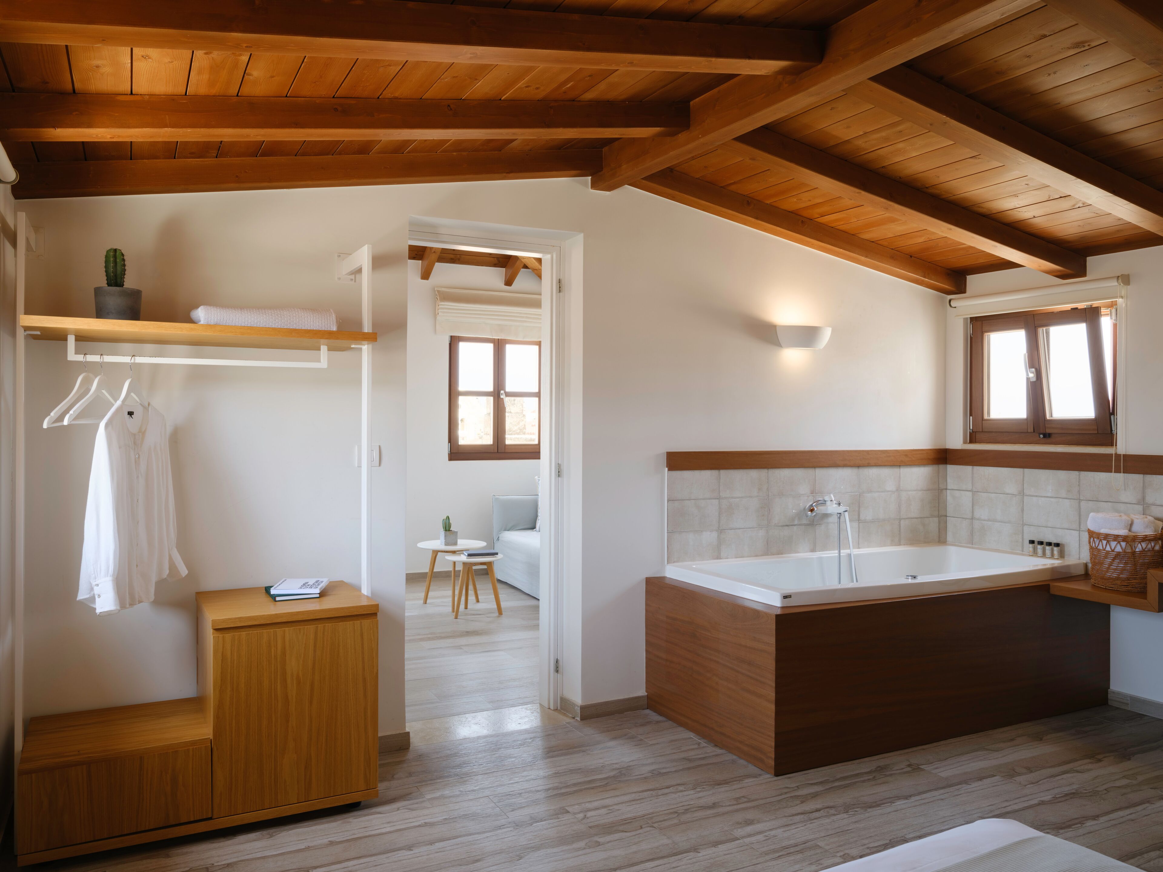A modern bathroom with a wooden vanity, a bathtub, and a shower area.