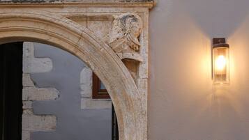 Un arco de piedra con inscripciones talladas y un accesorio de luz fijado a la pared.