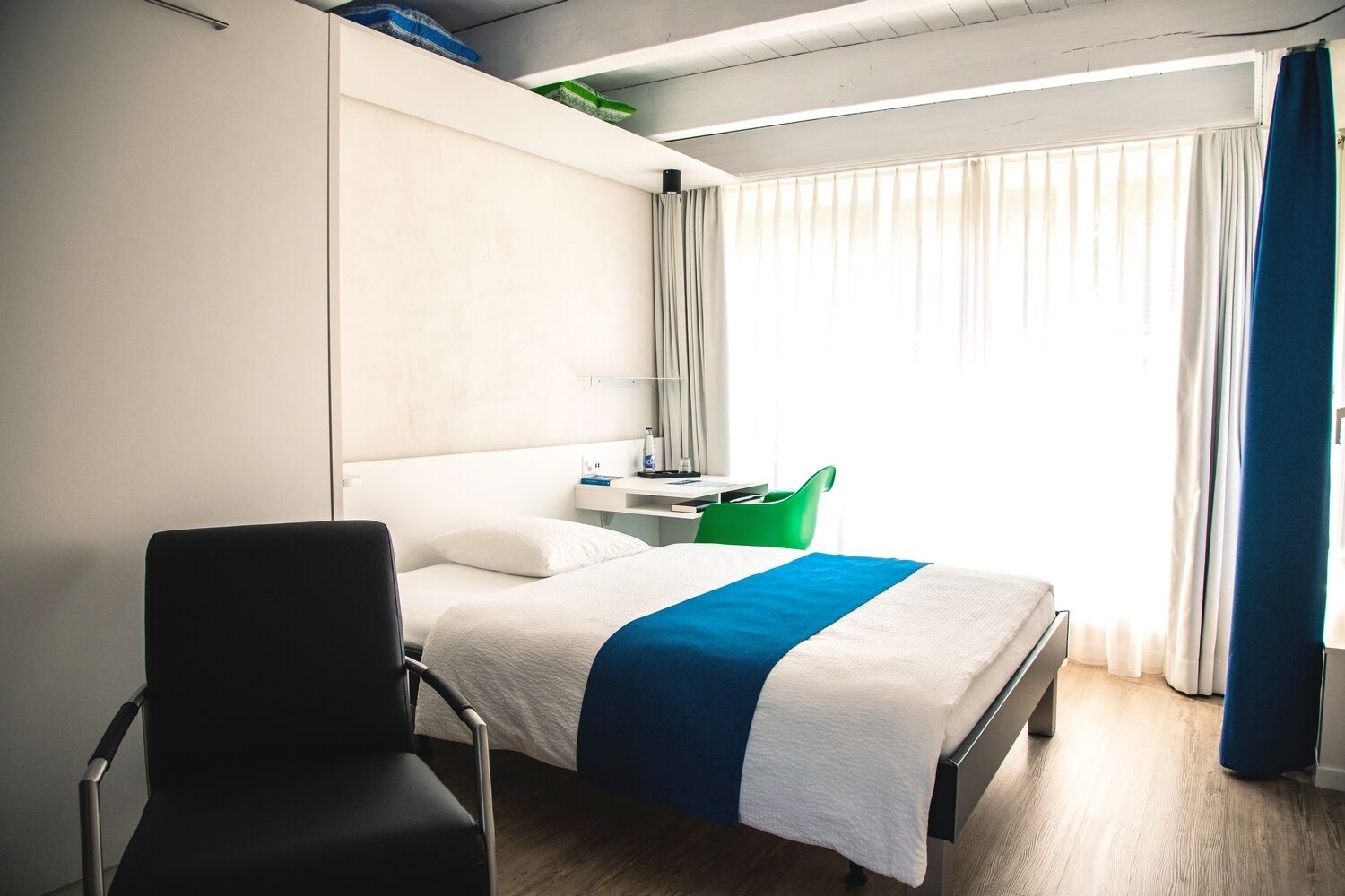 Hypo-allergenic bedding, desk, laptop workspace, blackout drapes