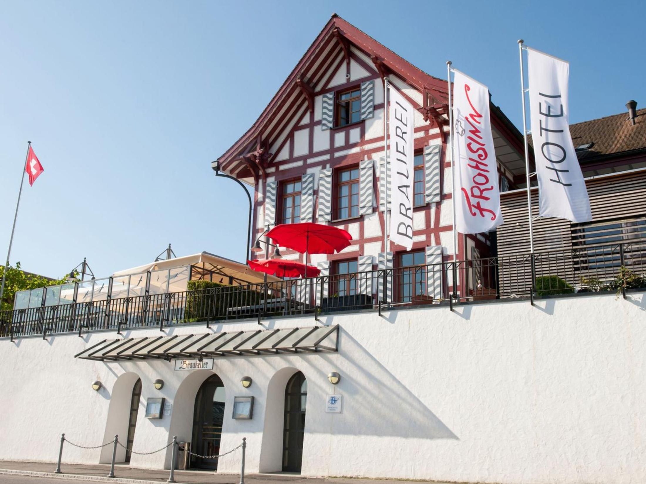 Um edifício tradicional em enxaimel com uma placa indicando 'Hotel Fromisheim'.