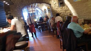 A restaurant with stone walls, wooden tables, and chairs. - Hotel Brauerei Frohsinn (Arbon)