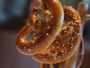 Un pretzel con sal en un palito de madera.