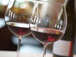 Duas taças de vinho com uma garrafa ao fundo.