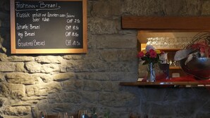 A restaurant interior with a chalkboard menu listing various brezel dishes and their prices. - Hotel Brauerei Frohsinn (Arbon)