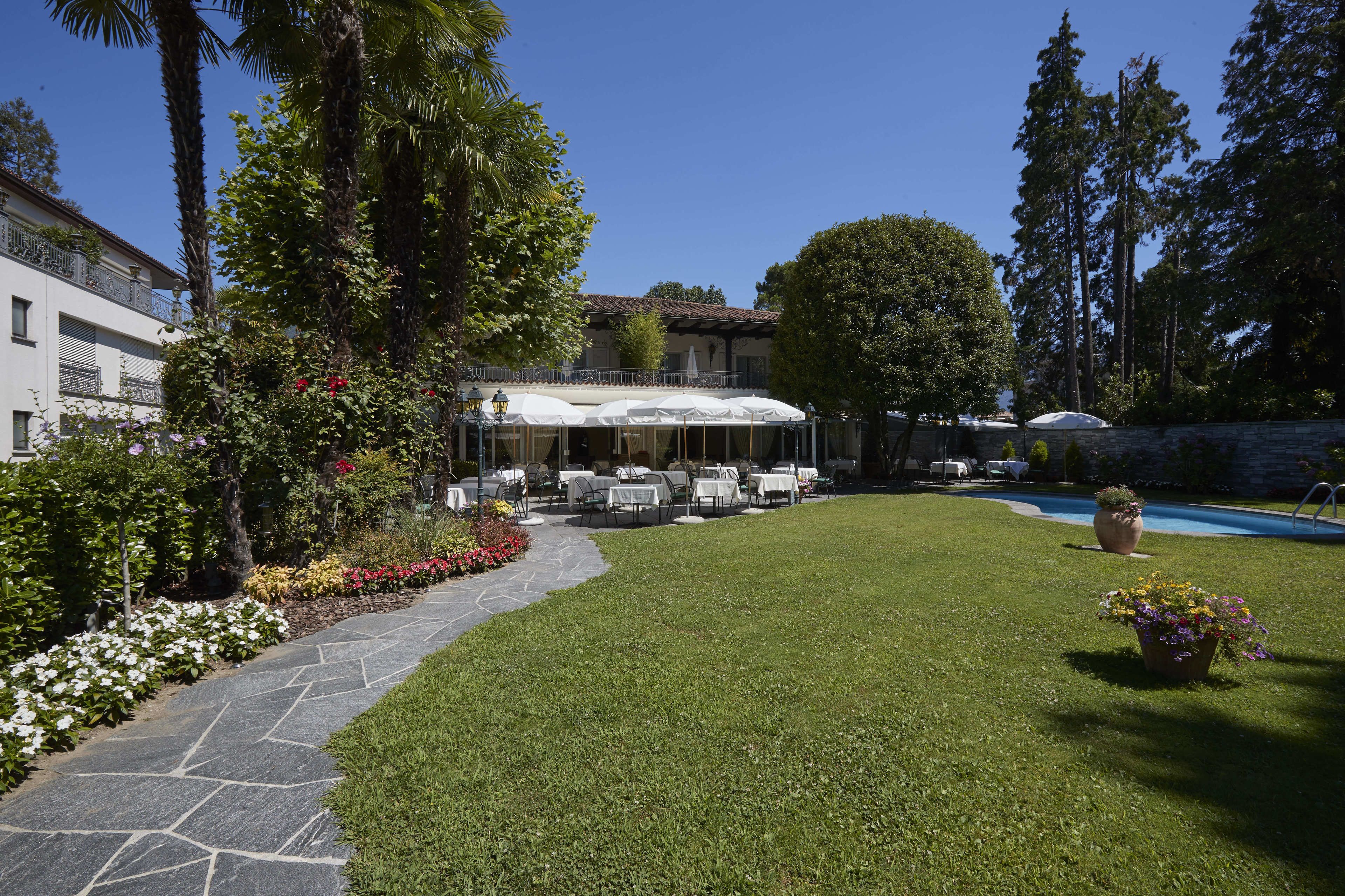 A courtyard with outdoor seating, a swimming pool, and a stone pathway.