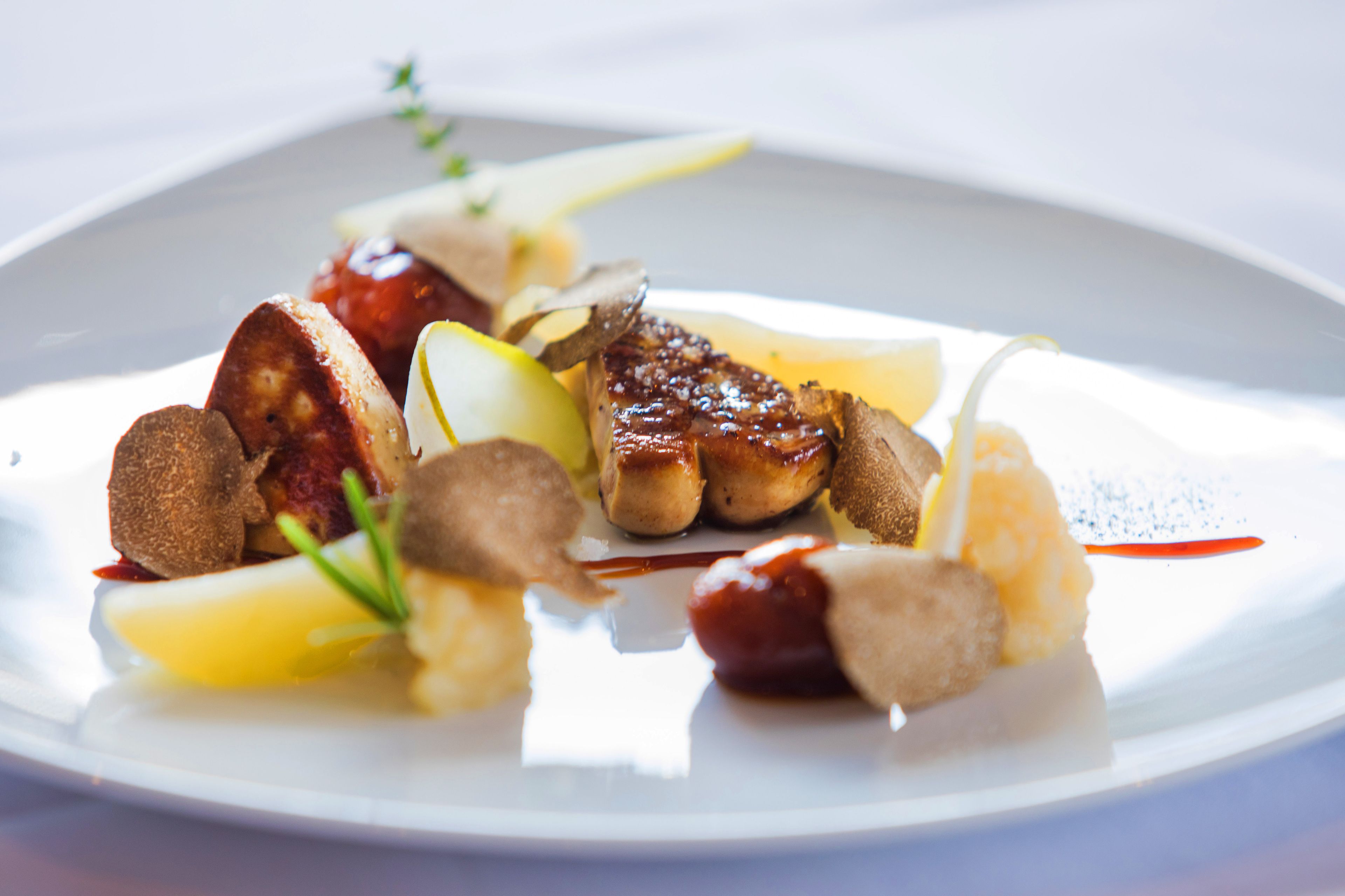 Un plato de comida con diferentes ingredientes, incluyendo carne, verduras y salsas.