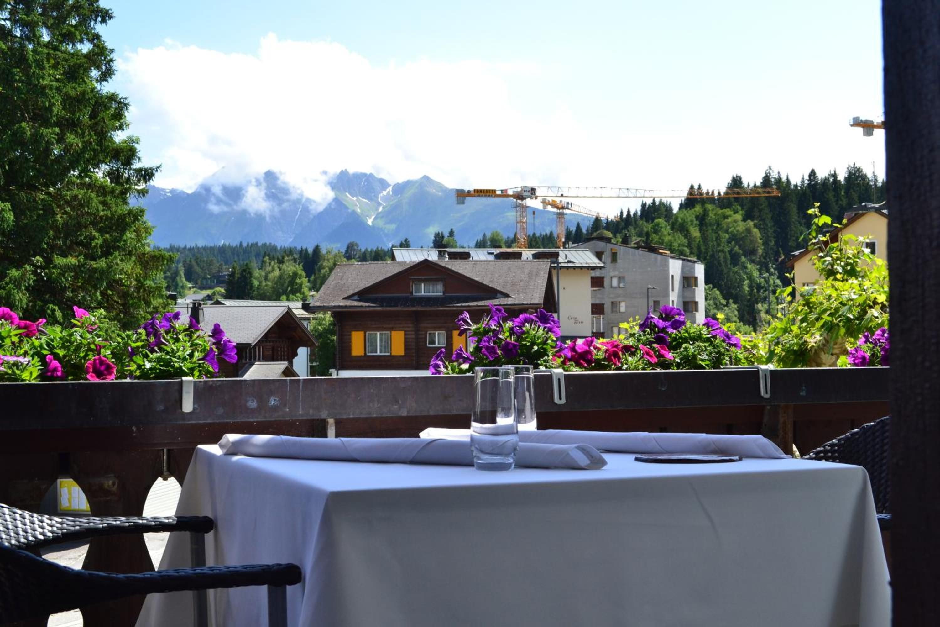 Une table dressée pour deux personnes, avec une vue sur les montagnes en arrière-plan.