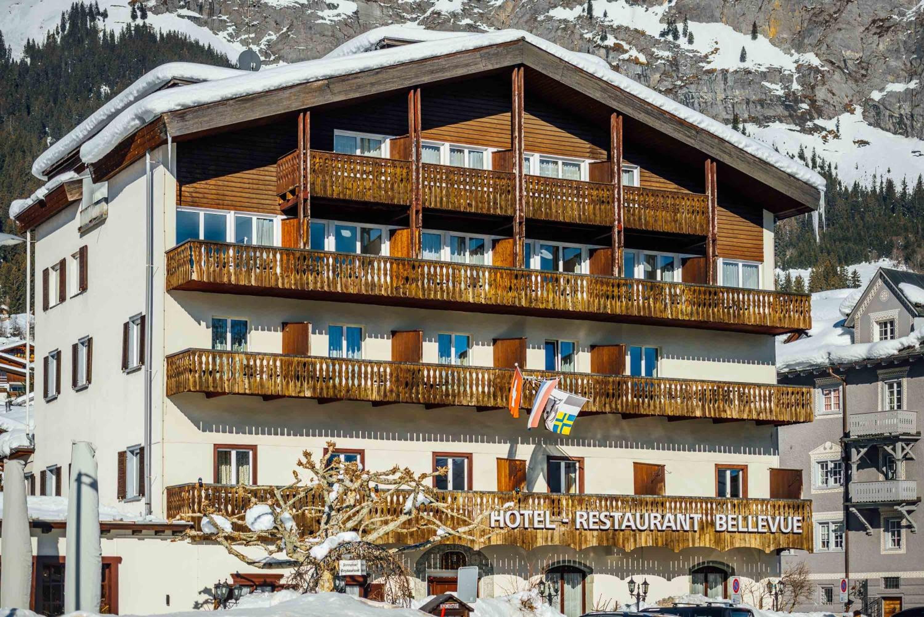 Un hôtel à plusieurs étages, doté de balcons et d’une enseigne indiquant la présence d’un restaurant.