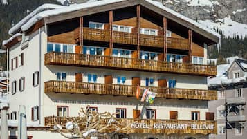 Un hôtel à plusieurs étages, doté de balcons et d’une enseigne indiquant la présence d’un restaurant.