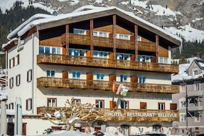 A multi-story hotel with balconies and a restaurant sign. - Hotel Restaurant Bellevue (Flims)