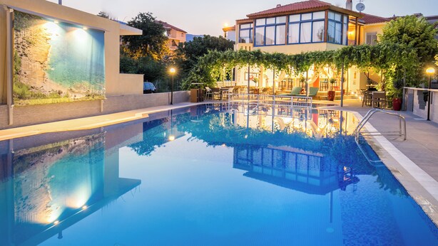 Una piscina con vista despejada a los edificios y la vegetación circundante.