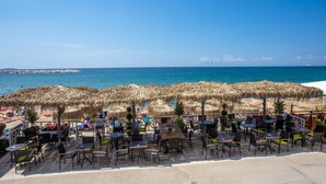 A beachside café with outdoor seating and umbrellas, overlooking the sea. - Thalassies Nouveau (Thasos)
