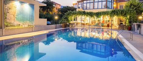 Una piscina amb una vista clara dels edificis i la vegetació circumdants.