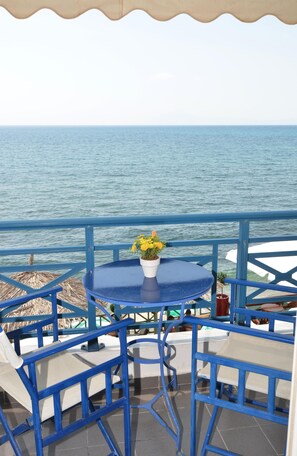 A blue outdoor seating area with a table and chairs, overlooking the sea. - Thalassies (Thasos)