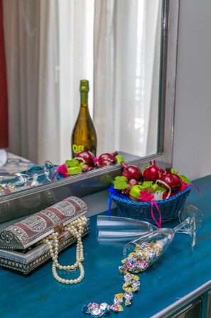 A table with a decorative basket, a bottle, a purse, and a glass with candies. - Thalassies (Thasos)