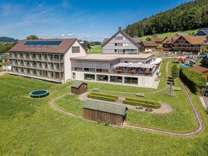 A modern hotel with a large outdoor area, multiple dining options, and a swimming pool.