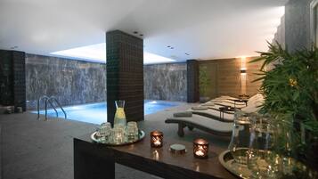 Relax in a serene indoor oasis with a pool, lounge seating, and a reception area.