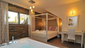 Ein Schlafzimmer mit einem Himmelbett, einem Schreibtisch und einer großen Badewanne.