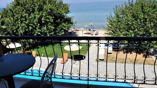 A balcony with a view of the sea, outdoor seating, and a pool. - Sunrise Beach (Thasos)