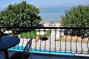 A balcony with a view of the sea, outdoor seating, and a pool. - Sunrise Beach (Thasos)