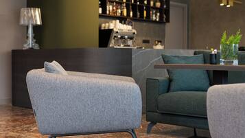 Un intérieur moderne comprenant un canapé, une table basse et un coin bar avec des étagères.