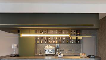 Un coin bar équipé d’une machine à café, d’une bouteille de champagne et d’un assortiment de bouteilles d’alcool.