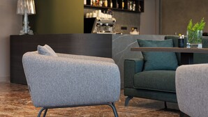 Un intérieur moderne comprenant un canapé, une table basse et un coin bar avec des étagères.