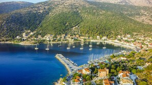 A coastal town with a marina, houses, and a mountainous backdrop. - Odyssey Boutique Hotel (Kefalonia)